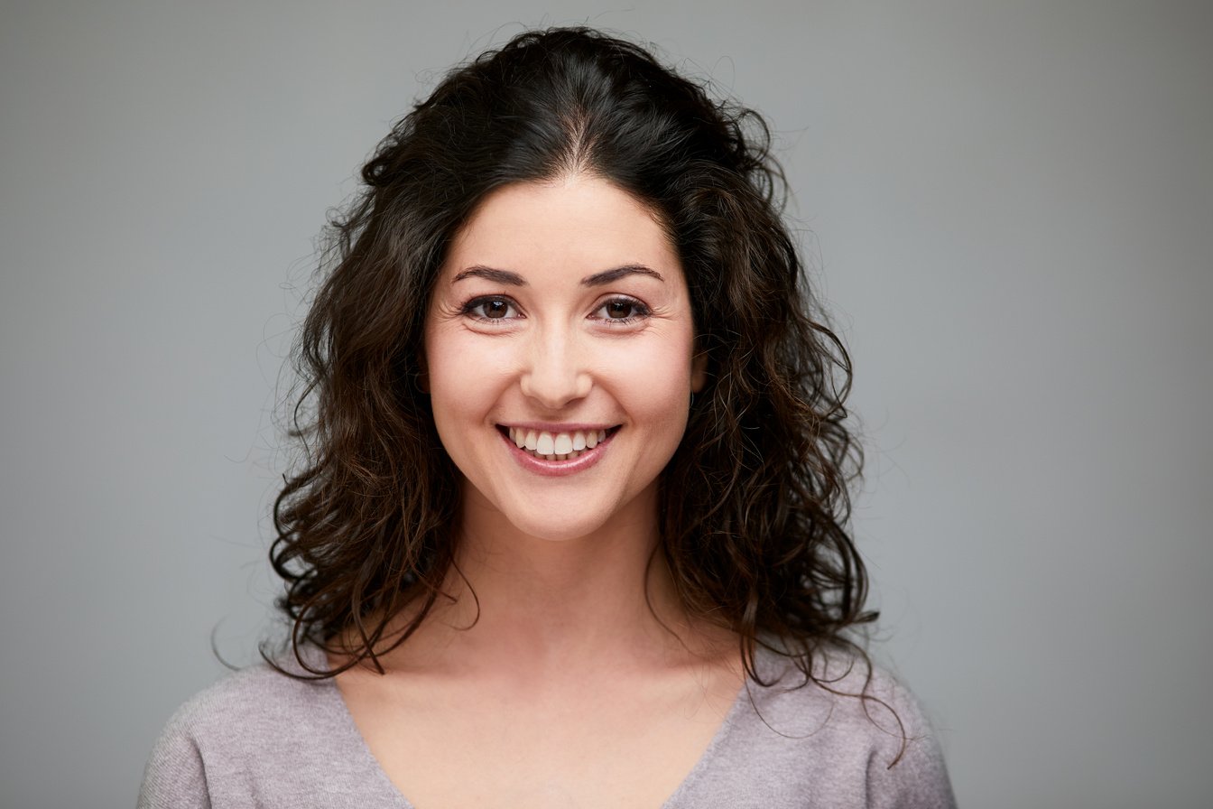 Young Spanish woman headshot wore looking at camera.